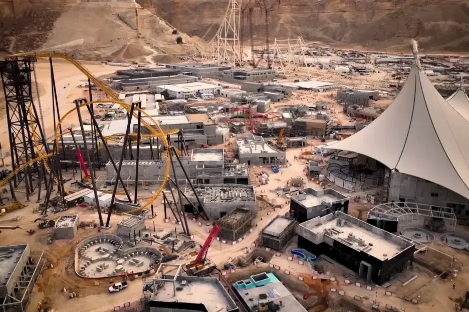 Aerial photo of the park under construction: bare earth, cranes, unfinished ride track